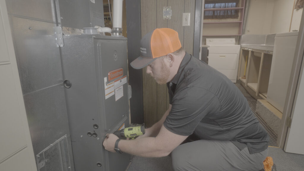 An HVAC tech examines a furnace